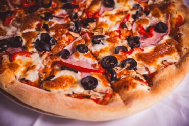 Pizza delicioasă cu ciuperci, măsline și ardei.