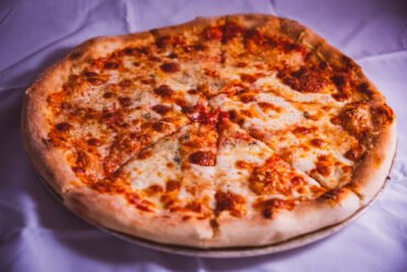 Pizza cu brânză delicioasă pe blat crocant.